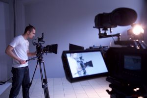 Filmowiec obsługuje kamerę podczas produkcji w profesjonalnym studiu filmowym
