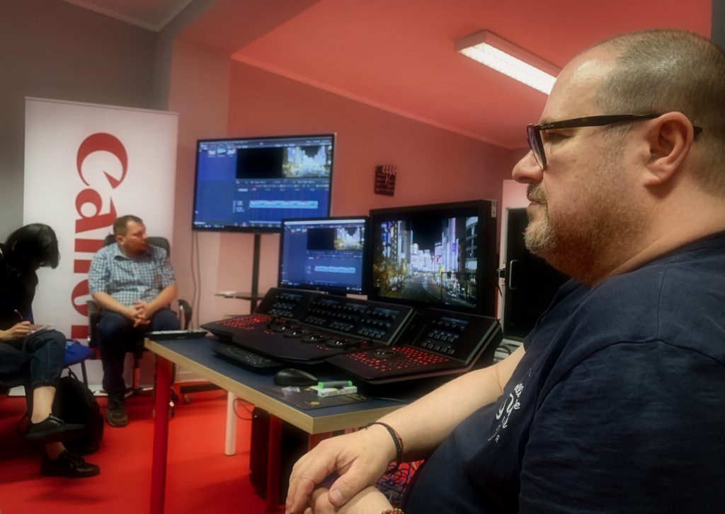 Mężczyzna pracuje przy komputerze edytującym wideo w studiu filmowym