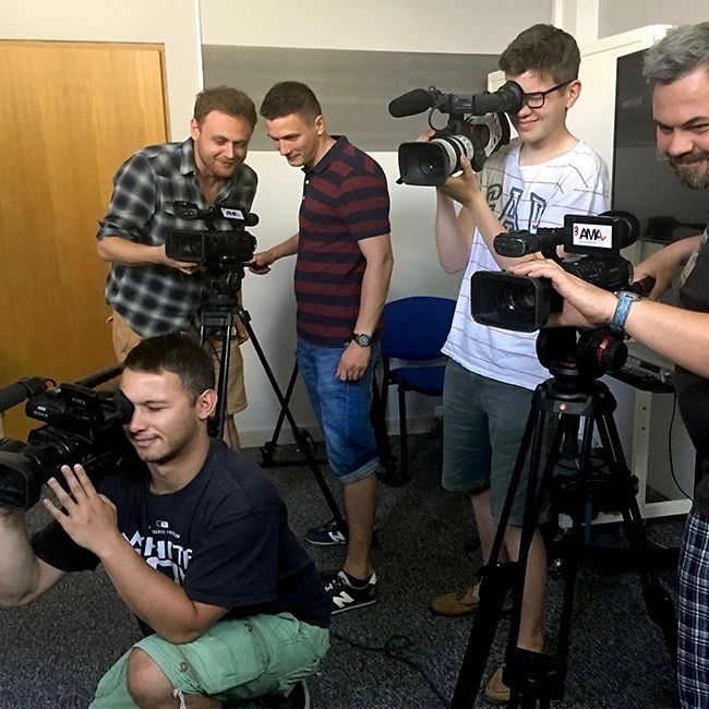 Studenci szkoły filmowej ćwiczą obsługę kamer wideo podczas zajęć praktycznych