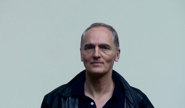 Portret mężczyzny w czarnej kurtce na białym tle studiowym