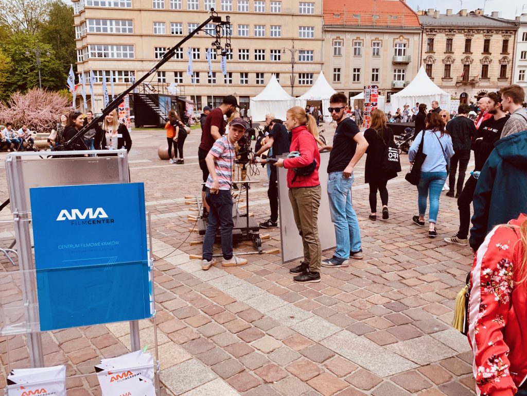 Impreza edukacyjna AMA Film Academy na placu miejskim z uczestnikami i namiotami