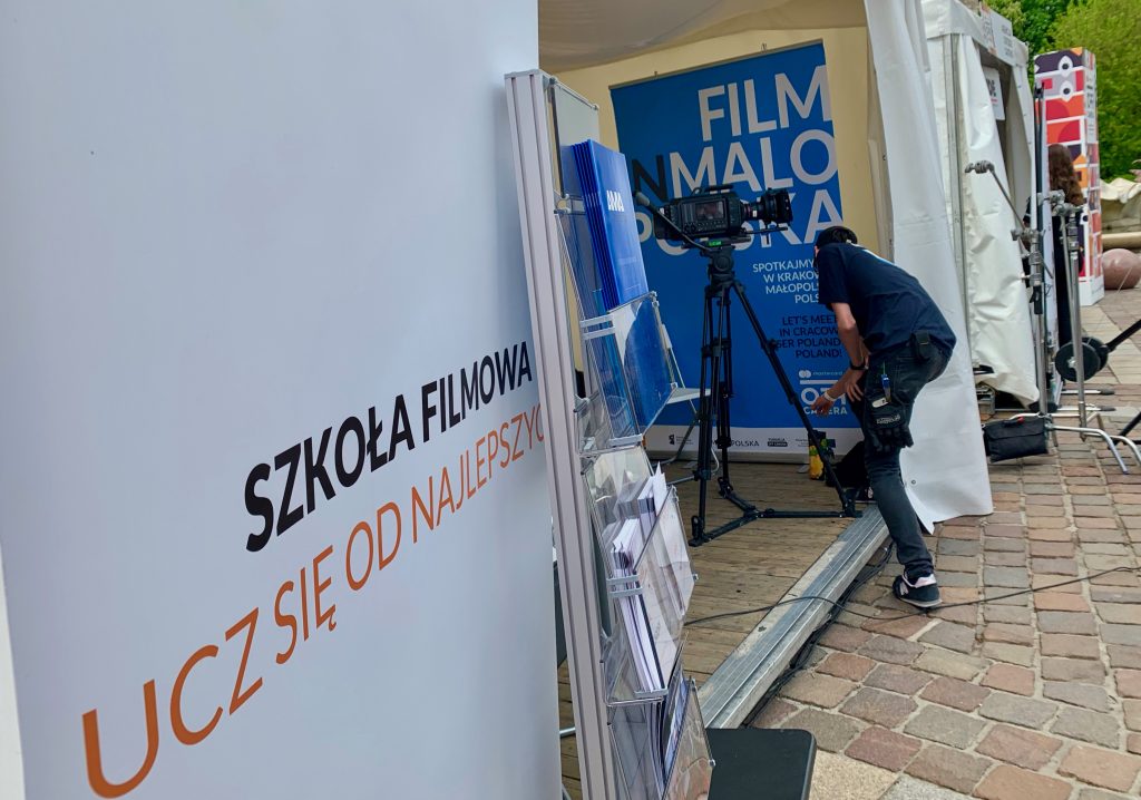Wejście do szkoły filmowej AMA Film Academy z niebieskim banerem i informacjami
