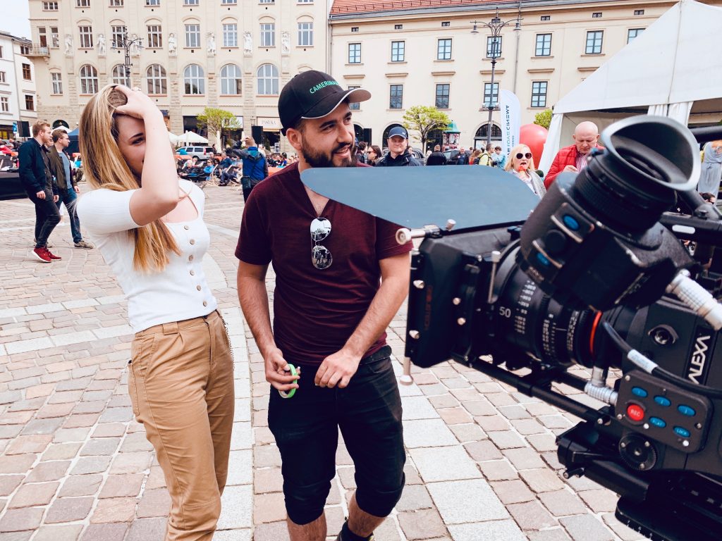 Studenci AMA Film Academy pracują ze sprzętem filmowym na placu miejskim