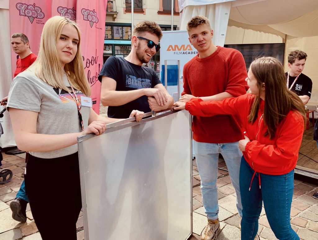 Uczniowie filmowej akademii pracują razem przy projekcie filmowym
