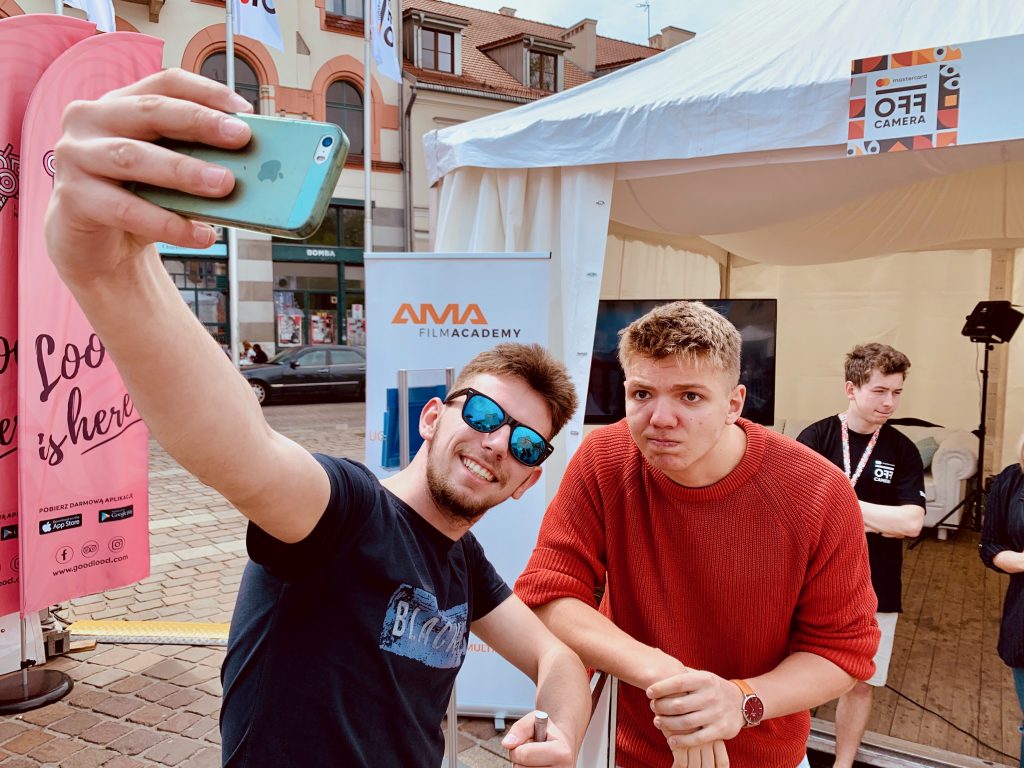 Studenci AMA Film Academy robią selfie na wydarzeniu szkolnym na placu