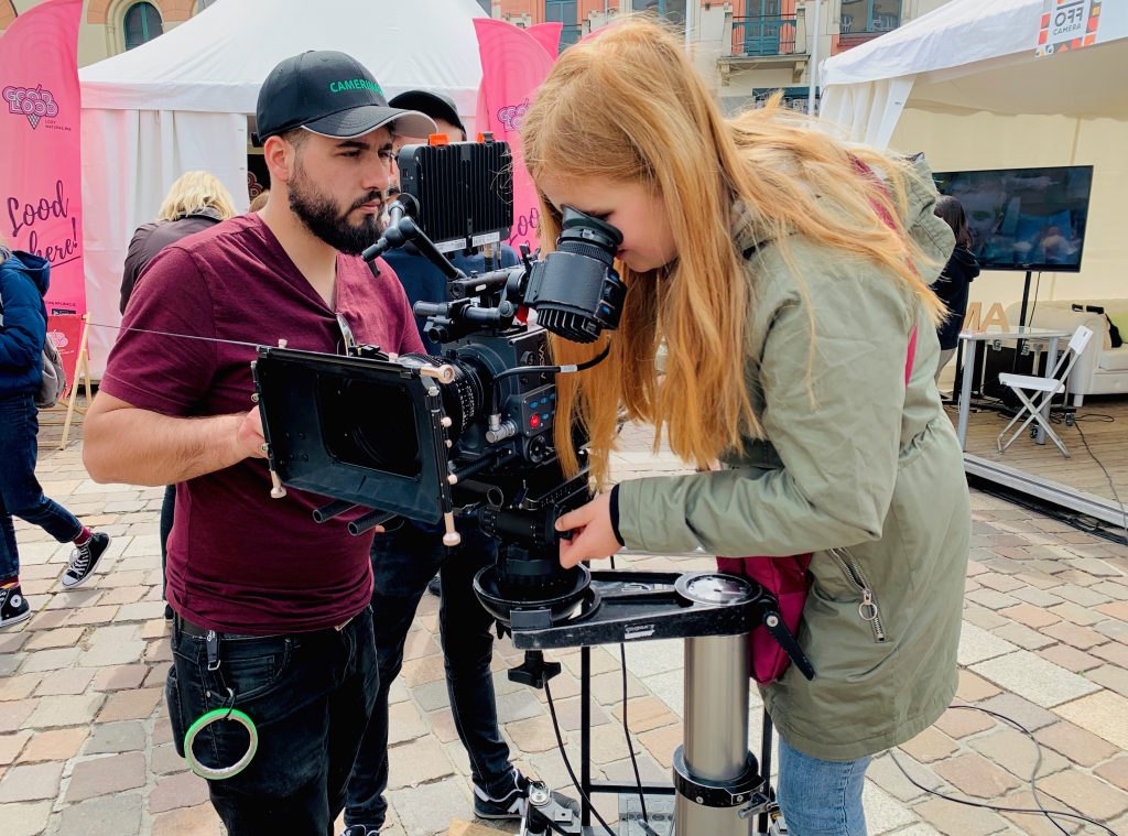 Kamerzysta i studentka oglądają footage na monitorze podczas produkcji filmowej