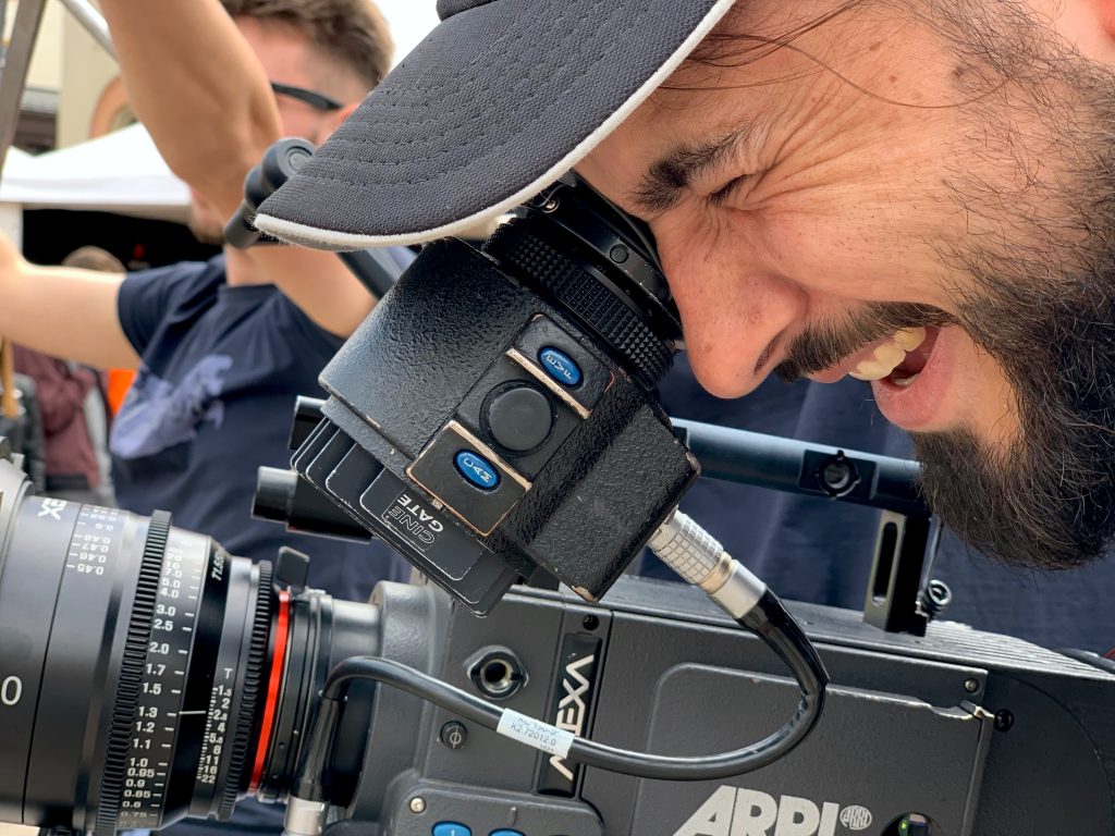 Videograf z kamera i obiektywem podczas pracy na planie filmowym