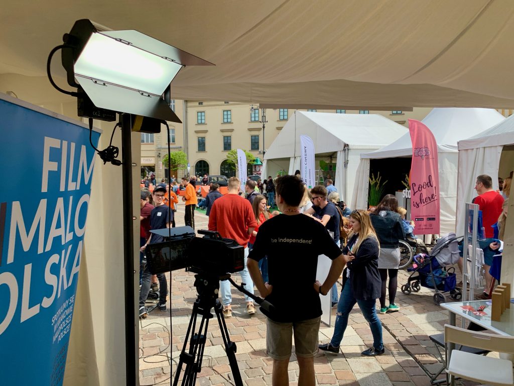 Plenery filmowe na placu z kamerami i uczestnikami wydarzenia
