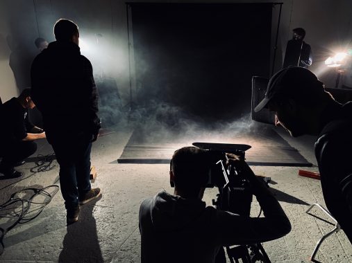 Filmowcy pracują na planie z dymem i profesjonalnym oświetleniem studyjnym