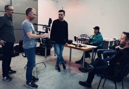 Grupa studentów szkół filmowej podczas praktycznego warsztatu z obsługą sprzętu kamerowego