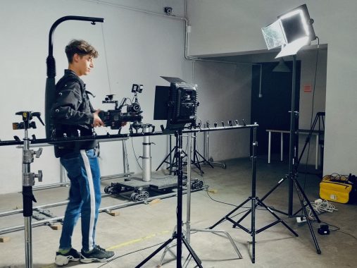 Młody chłopak w studiu filmowym przy profesjonalnym sprzęcie do produkcji wideo