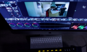 Monitor z oprogramowaniem do montażu wideo i klawiatura na biurku