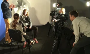 Studenci szkoły filmowej pracują przy kamerze podczas nagrań na planie filmowym