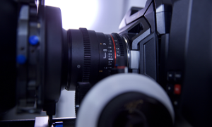 Profesjonalny sprzęt do filmowania, kamera z obiektywem na statywie w studiu