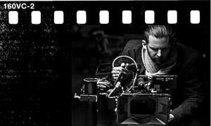 Filmowiec pracuje przy kamerze filmowej podczas produkcji, czarno-białe zdjęcie