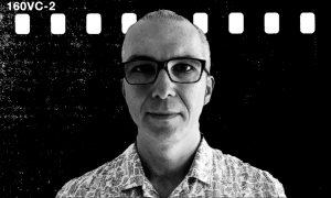 Portret mężczyzny w okularach na tle filmu czarno-białego