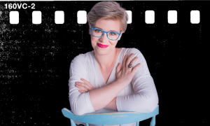 Portret kobiety w okularach i różowej szmince na tle filmowym