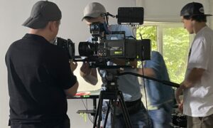 Trzaj mężczyzni pracują przy profesjonalnym sprzęcie filmowym podczas zajęć