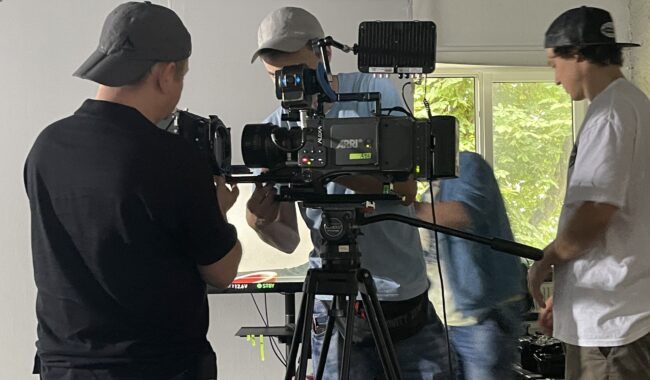 Trzaj mężczyzni pracują przy profesjonalnym sprzęcie filmowym podczas zajęć