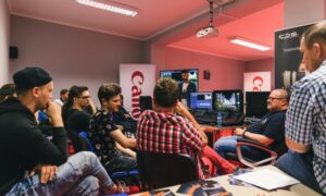 Grupa studentów uczestniczy w warsztatach postprodukcji filmowej w nowoczesnym studiu
