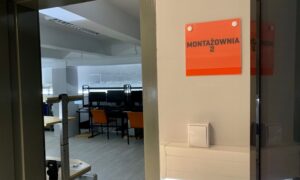 Wejście do pracowni montażu z pomarańczową tabliczką Montażownia