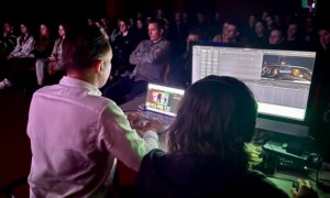 Edytor montażu filmowego pracuje przy monitorach podczas pokazu dla studentów szkoły filmowej