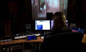 Producent dźwięku pracuje przy stanowisku w profesjonalnym studiu nagraniowym