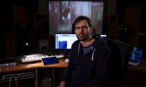 Mężczyzna w studiach dźwięku przy stanowisku producenckim z instrumentami muzycznymi