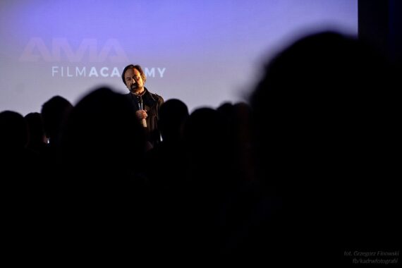 Mężczyzna przemawia na scenie przed publicznością podczas inauguracji AMA Film Academy