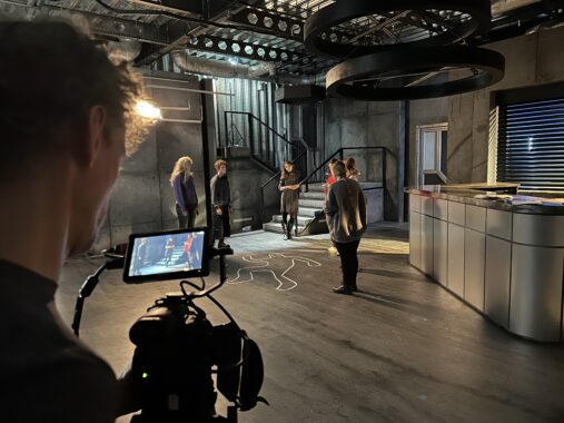 Filmowanie sceny w studiu z kamerą, aktorami i oświetleniem studyjnym