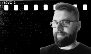 Portret mężczyzny w okularach, czarno-białe zdjęcie, pas filmowy