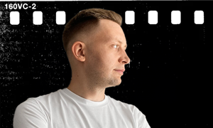 Portret mężczyzny w profilu w białej koszulce na czarnym tle