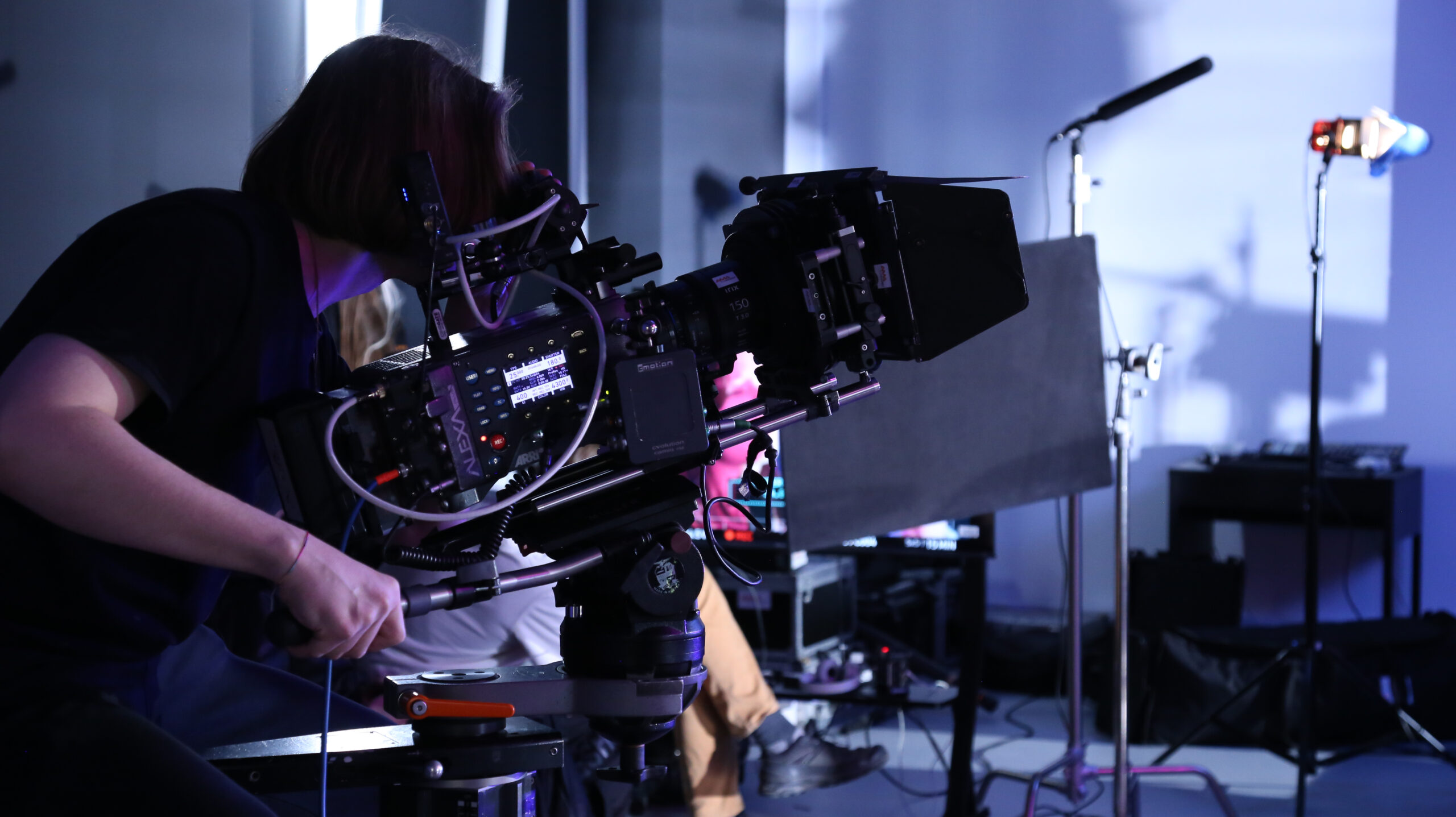 Kamerzysta podczas nagrywania materiału filmowego na profesjonalnym sprzęcie w studiu