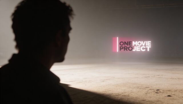 Sylwetka osoby patrzącej na neonowy napis One Movie Project w pustej przestrzeni