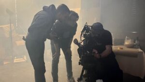 Zespół filmowy pracuje z kamerą w mglistym studiu produkcyjnym